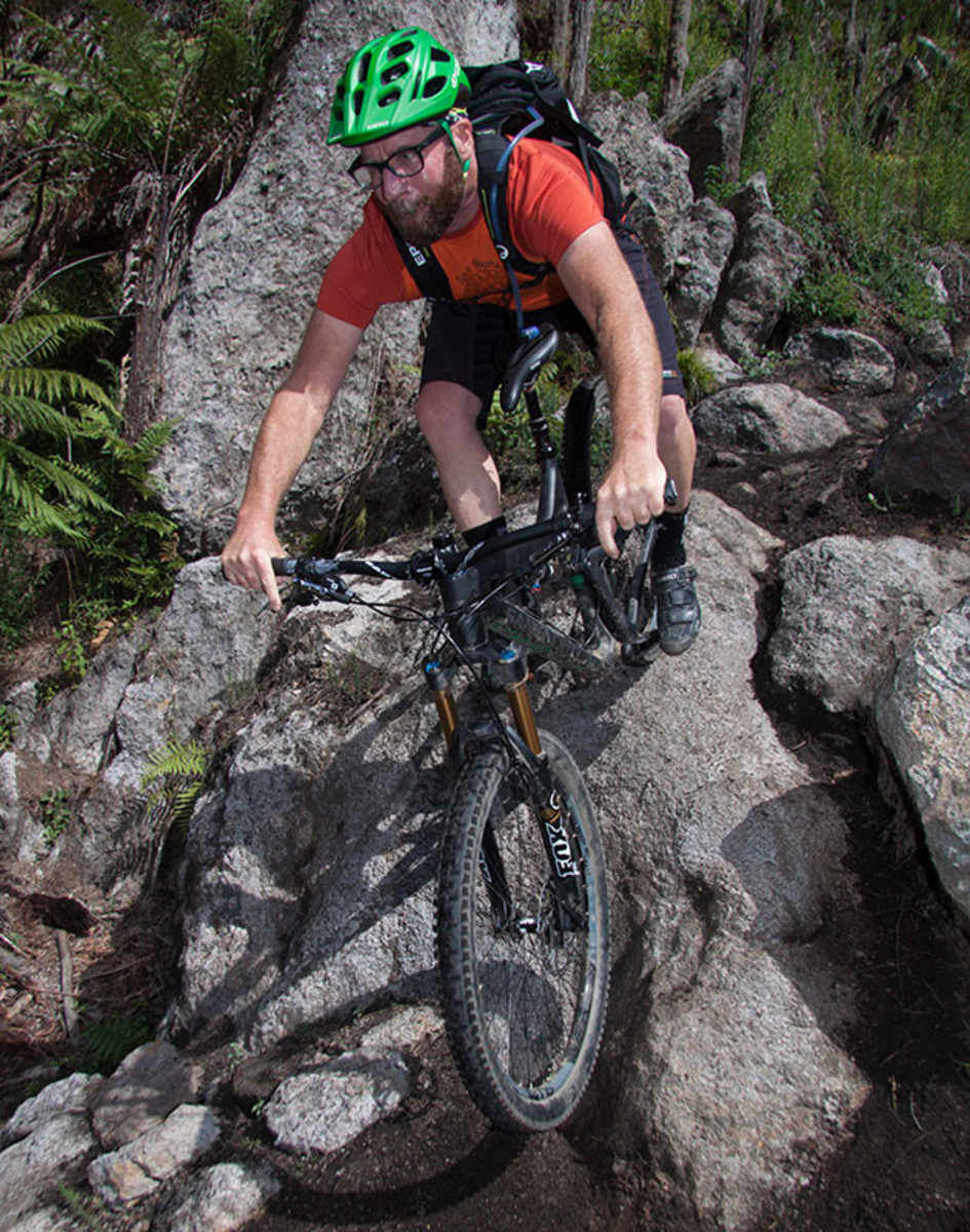 This is what it looks like when you are trying to keep up with a local who loves to keep you at your limit up the climbs then drop you into techy bits you have never ridden before without any warning what may be in store. Extra-bonus points when there just happens to be a photographer set up at the bottom of the section, staking out his spot for the national champs tune-up race about to start… BoulderDash trail, Whakarewarewa Forest, Rotorua. PHOTO: Alan Ofsoski www.fotoengineers.com