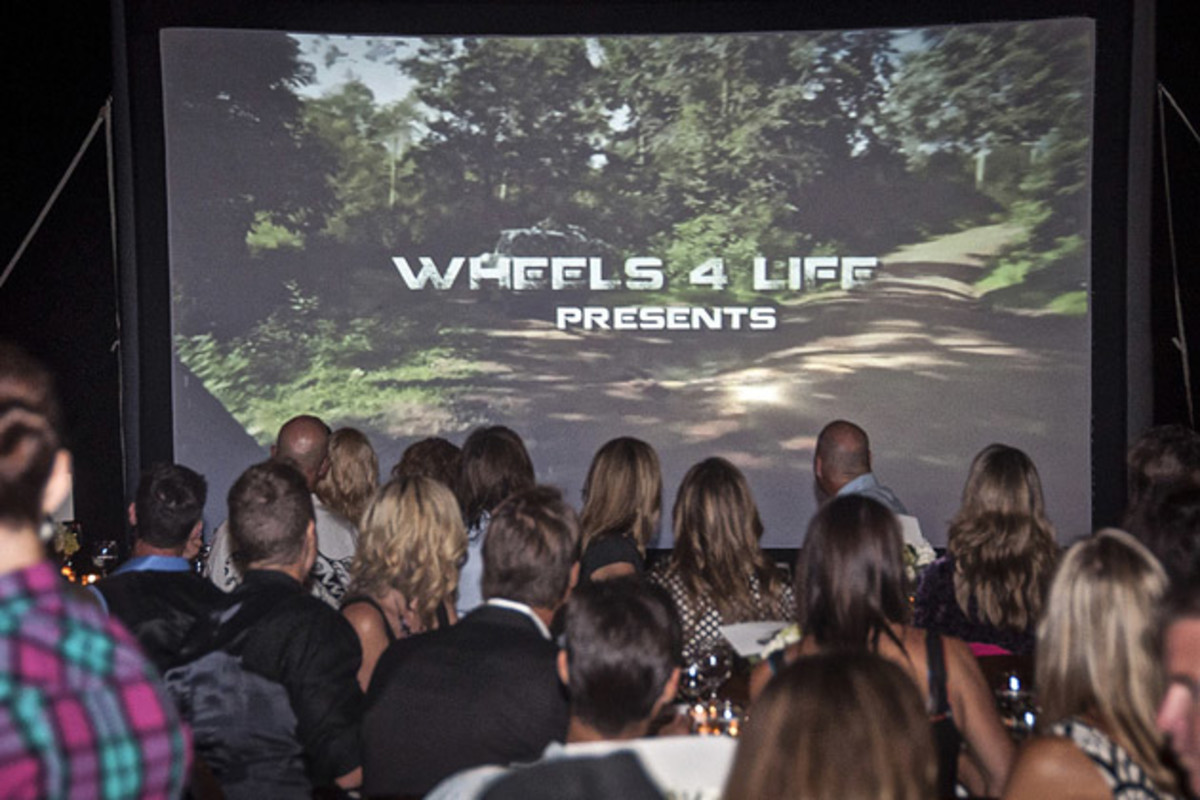 The crowd watches a premier of Wheels 4 Life's latest film "Riding Out of Poverty"