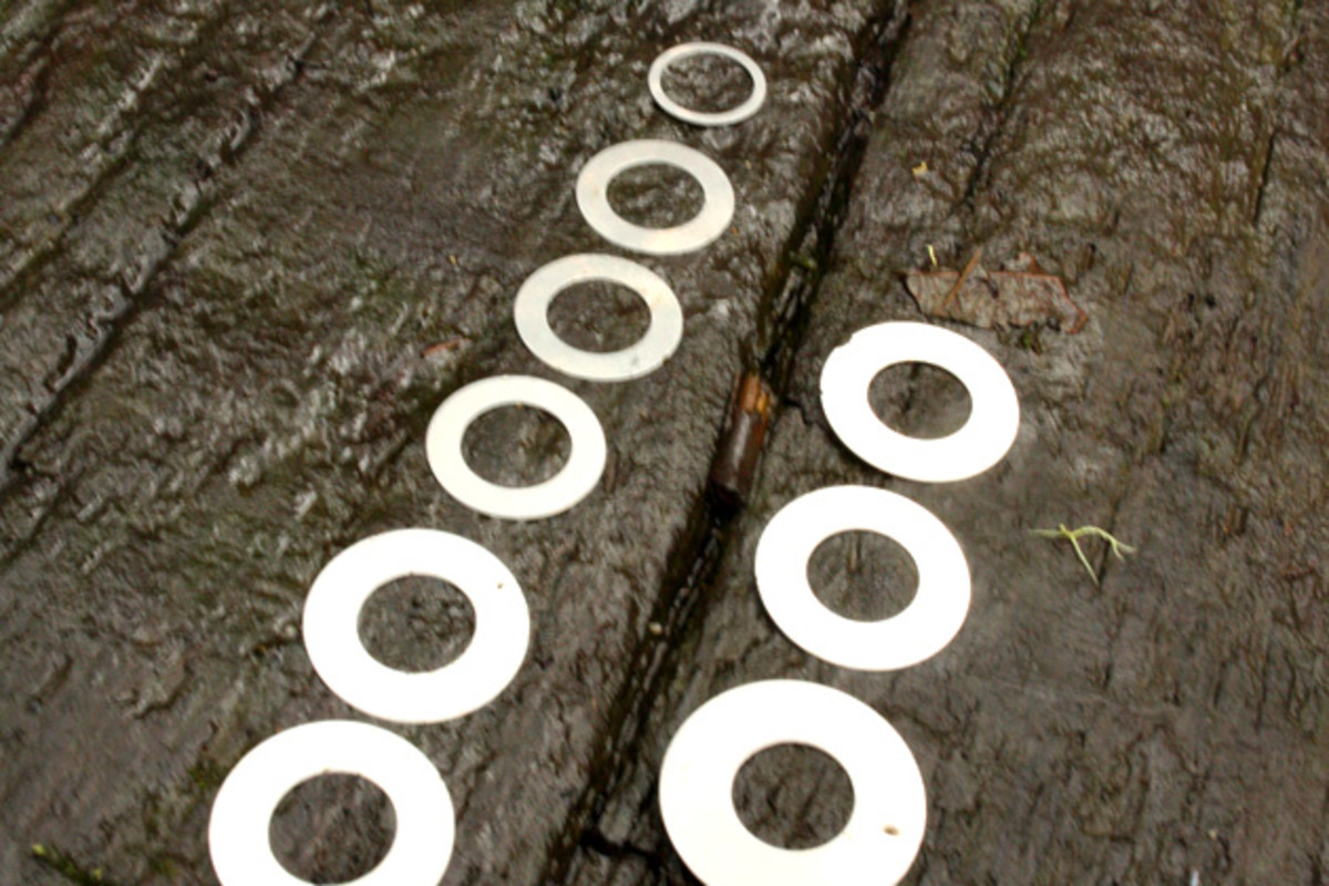 There are a gang of shims lurking inside the FIT4 damper–these are just the tail end of `em. Up top, you've got E16. Down below, you have the original set up. Such a small difference inside the fork yields a definite bump in performance out on the dirt.