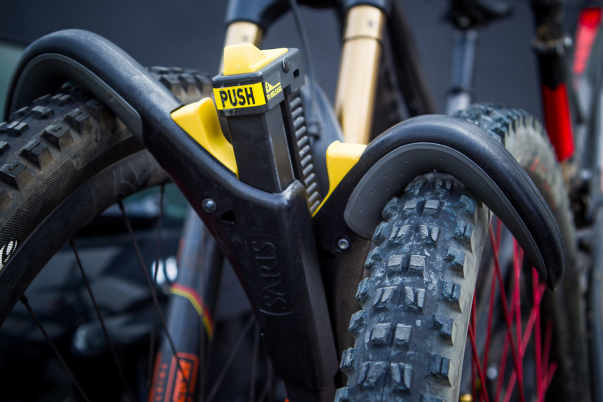 There's no need to reach down to strap wheels down, just push the top button to angle the upright support over the tire, and push the hook against it. Super quick, super solid, Superclamp.
