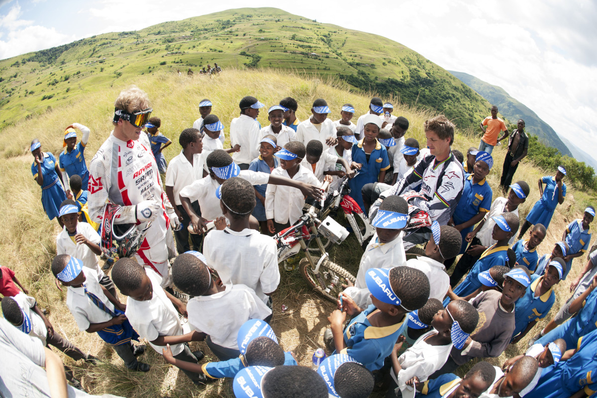 Steve Peat and Greg Minnaar surrounded by kids from the Msayana School in the Umkomaas Valley.