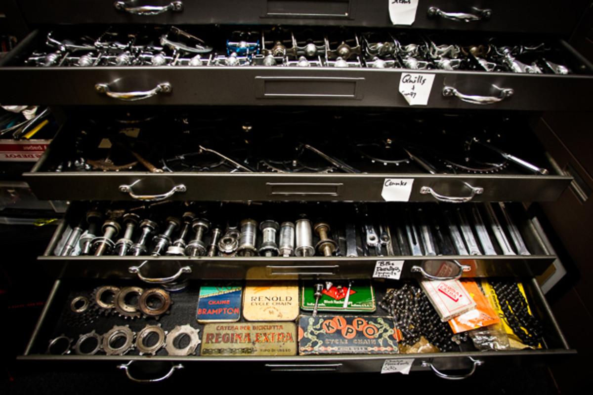 Drawers of neatly organized vintage catalogs, hubs, cranksets and more pedals fill the back of Bryne's workspace.