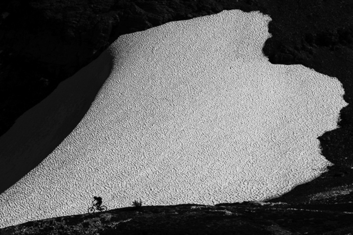 I love spending as much time as I can in the alpine during the summer months. Luckily, we have an abundance of it surrounding Revelstoke. Here, Jordy Lebel cruises down in front of the remnants of a huge winter snow drift. The texture of the snow is what caught my eye when we set up for this shot. The sun cups in the snow, created a beautiful repeating pattern that we shot more than once. A different version of this shot ran in Bike magazine's 2013 Photo Annual. Rider: Jordy Lebel Location: Selkirk Mountains, British Columbia. Photo courtesy of Bruno Long