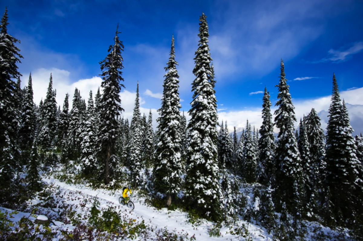 This was definitely the last ride of the season, in the alpine, for Nash and me. We only made it about halfway up the trail before it got too deep for us to continue. Deciding to turn around, we noticed the clouds parted during our descent, and we had a chance to ride down in the sun, with snow blanketing the forest. It was quite surreal and the first time I've ever made fresh tracks on my bike. Rider: Nash Masson Location: Monashee Mountains, British Columbia. Photo courtesy of Bruno Long