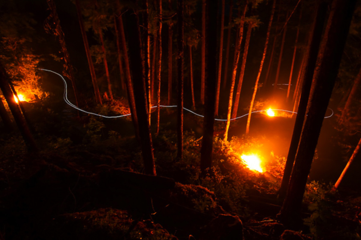 While working as a firefighter in Revelstoke, my friend Marty mentioned that he had been working on a forest safety project by piling up ladder fuels and dry timber for burning—helping to protect the forest from fires by reducing the amount of fuels available. He told me which days they were burning the piles, and we made a plan to hit up a piece of trail close to the road for a night shot. I attached a light to the front and back of Marty's helmet, and with a little help from a friend (to keep the fires burning bright), we came away with this unique image that I was quite happy with. Rider: Marty Schaffer. Location: Mt. Macpherson, Revelstoke, British Columbia. Photo courtesy of Bruno Long