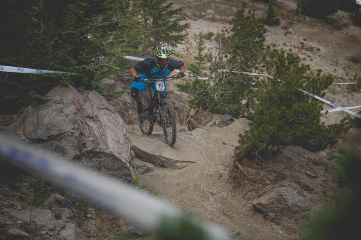 Rides left the ski run for a short jaunt in the trees. This rock was about the only solid part of a section filled with deep sand and peppered with small rock drops. More than a few riders had trouble staying upright through here, Drew Anderson, 13th overall, prepares to get loose.
